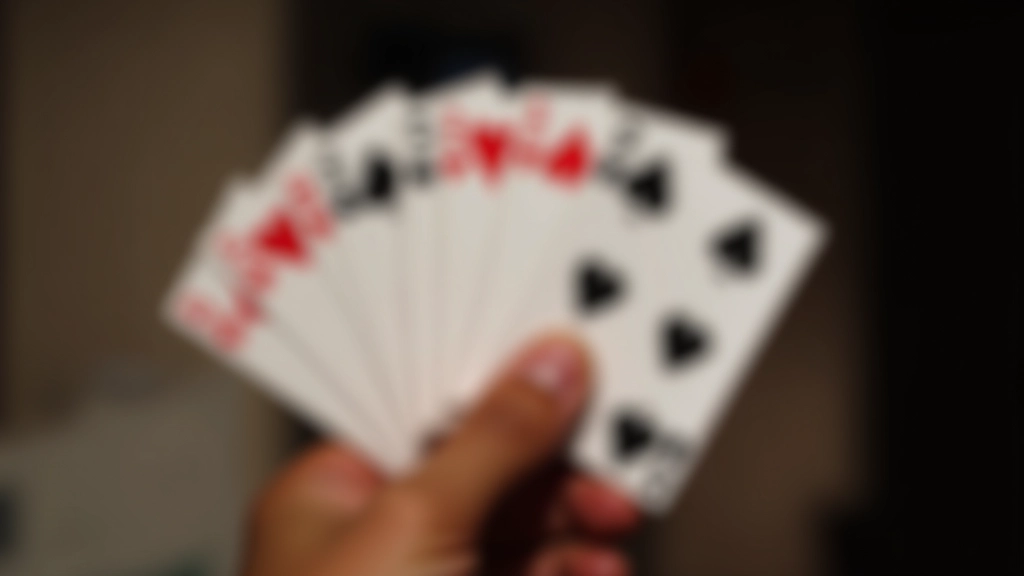 Close-up view of bridge cards fanned in hand showing suit hierarchy and numbered rankings clearly